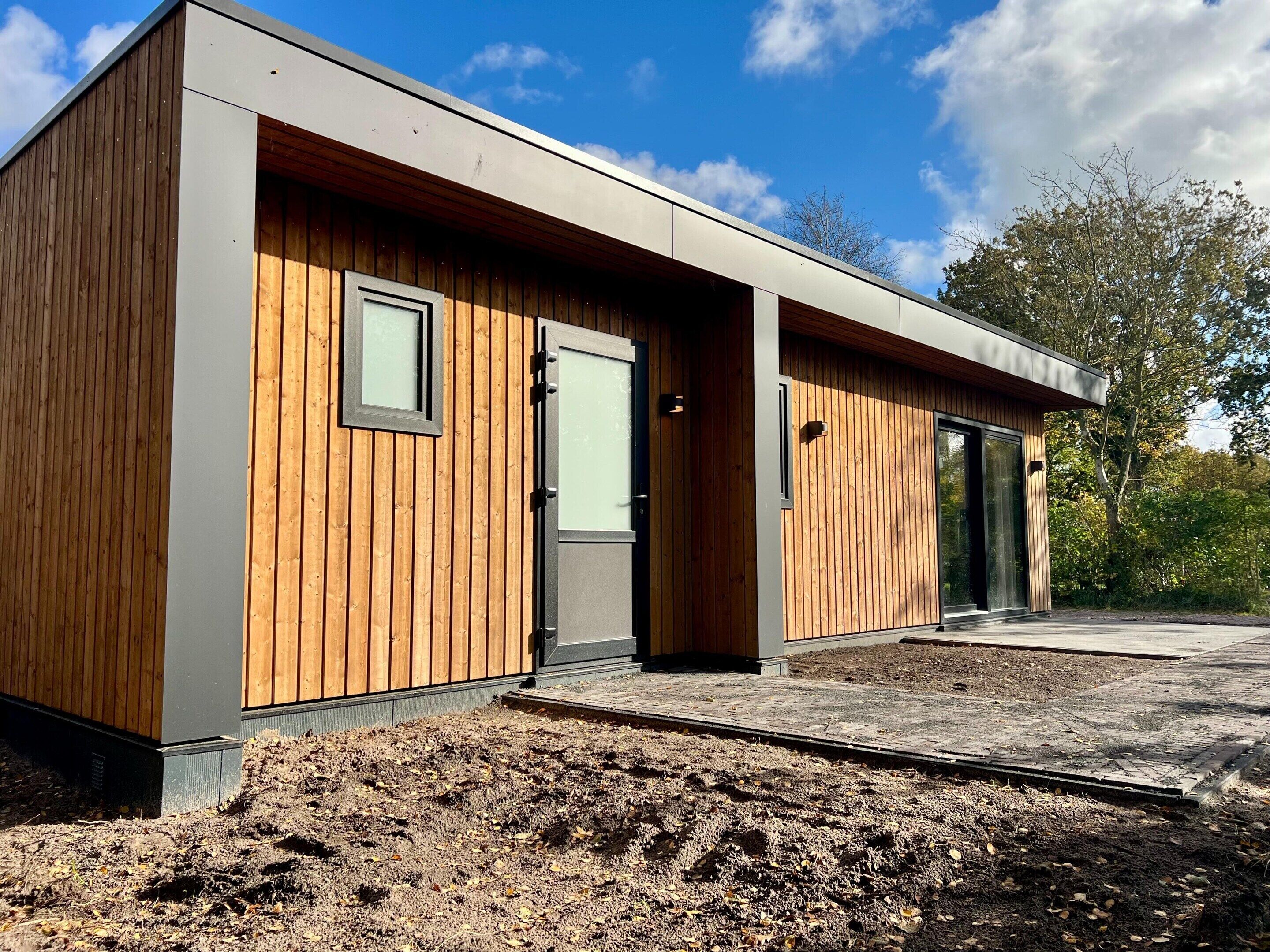 A modern building with a wooden exterior, a door, and a window.
