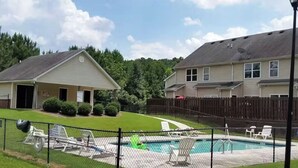 Ein Wohngebiet mit Schwimmbad, umzäunter Garten und zwei Häusern.