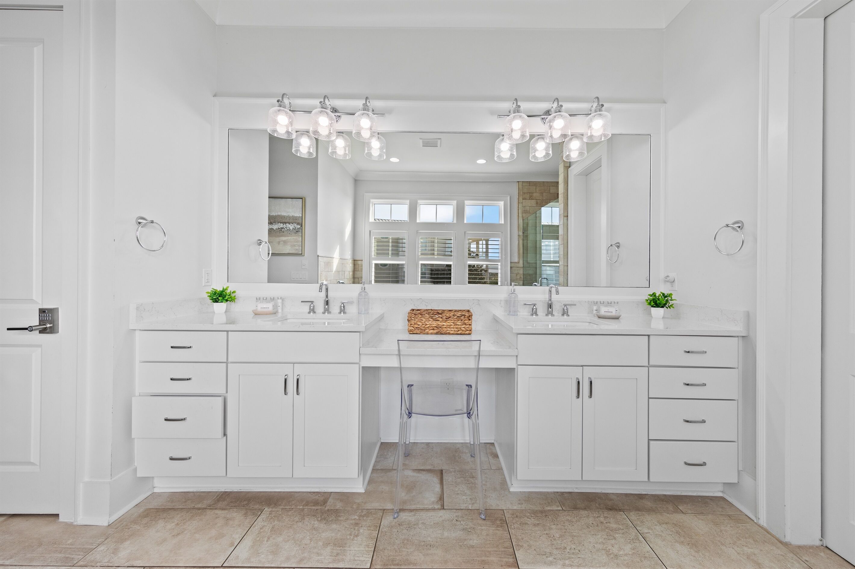 A modern bathroom with two sinks, a large mirror, and overhead lighting.