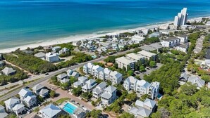 Vista aérea de una zona residencial costera con casas, una playa y un océano azul y despejado.