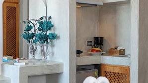 A kitchen with a marble countertop, a coffee machine, and a fruit bowl. - Sea & Sky Luxury Beach House – Elegant Cycladic Studio by Agia Paraskevi Beach (Kamari)