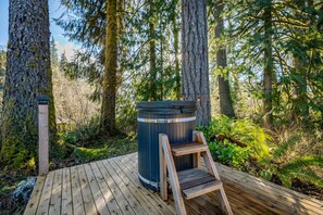 Eine Holzterrasse mit Whirlpool und einer Holzleiter.