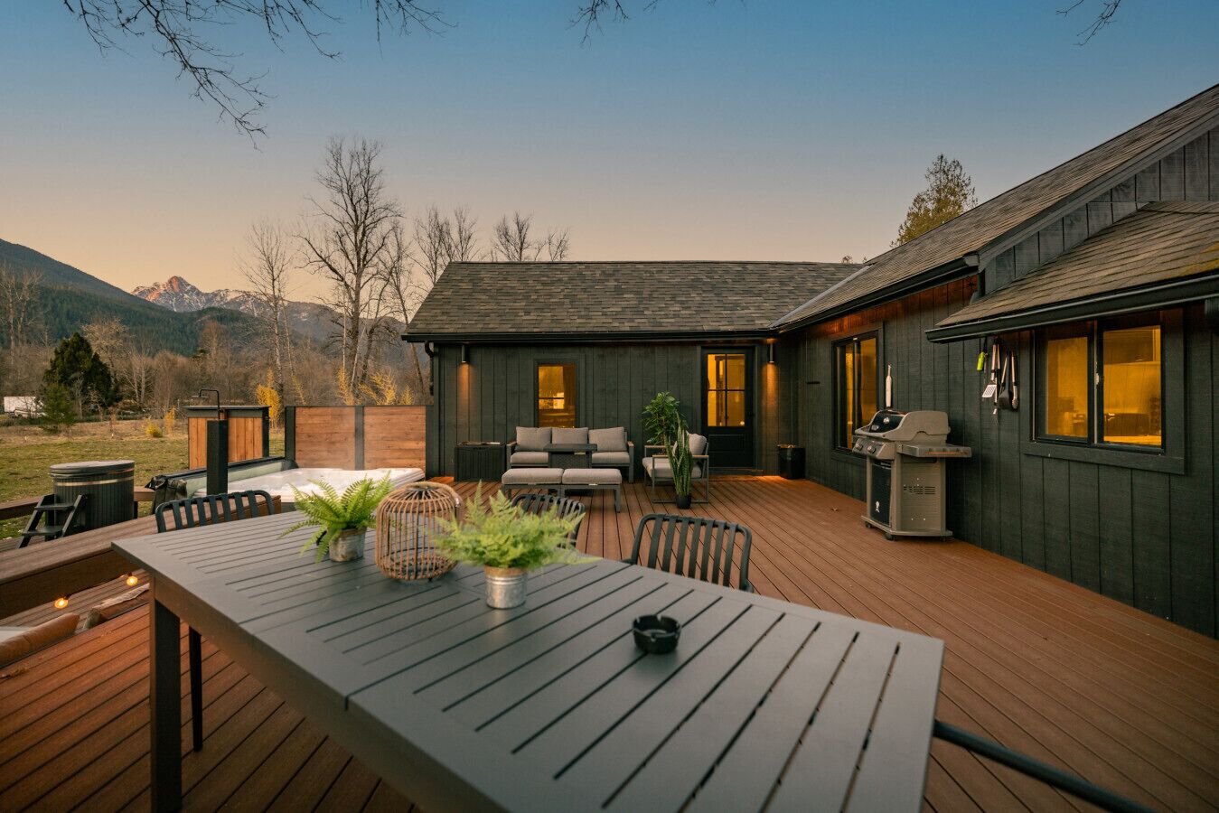 A deck with a table, chairs, and a grill.