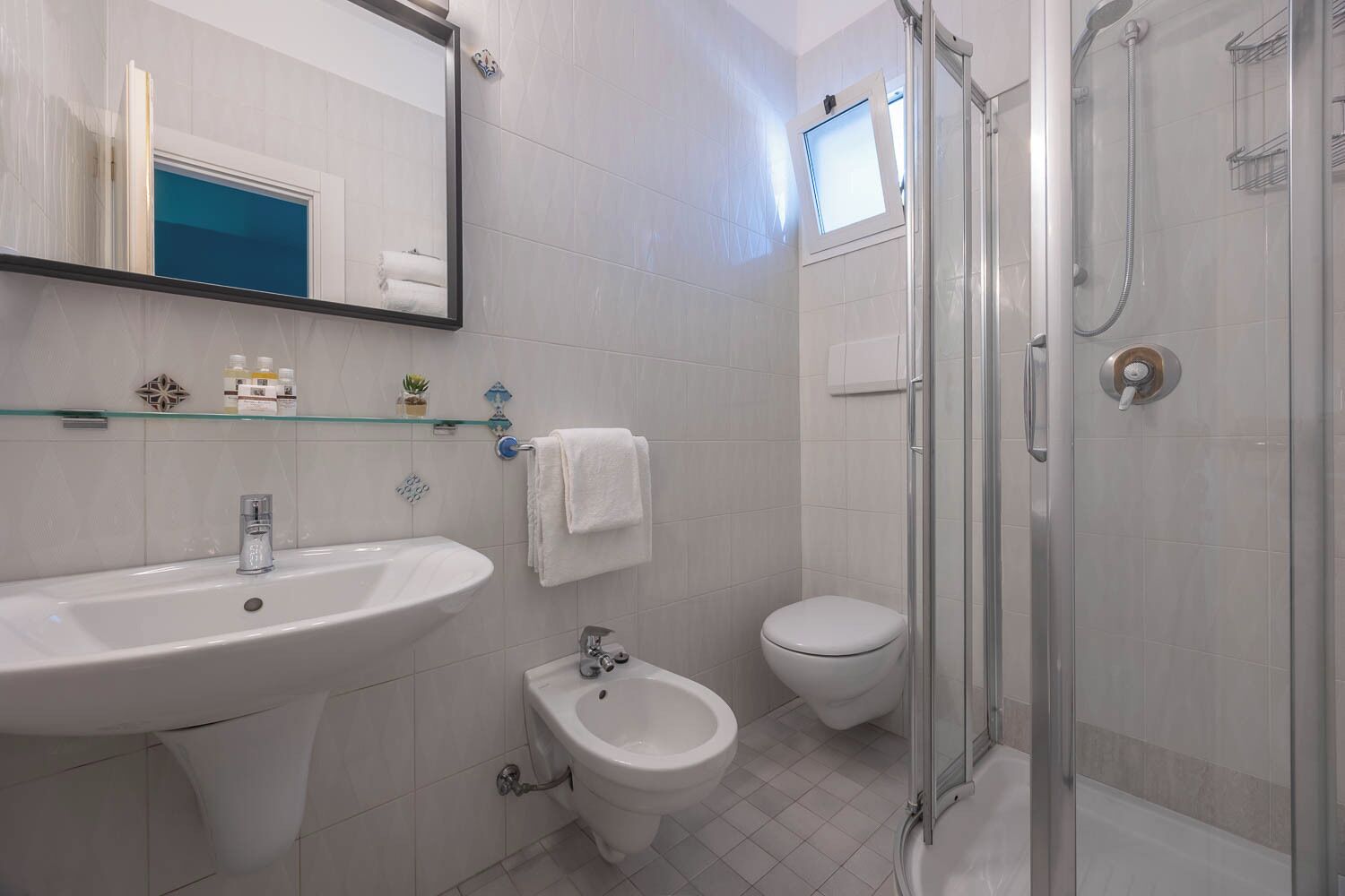 Ein Badezimmer mit Waschbecken, Bidet, Toilette und einer Duschkabine.