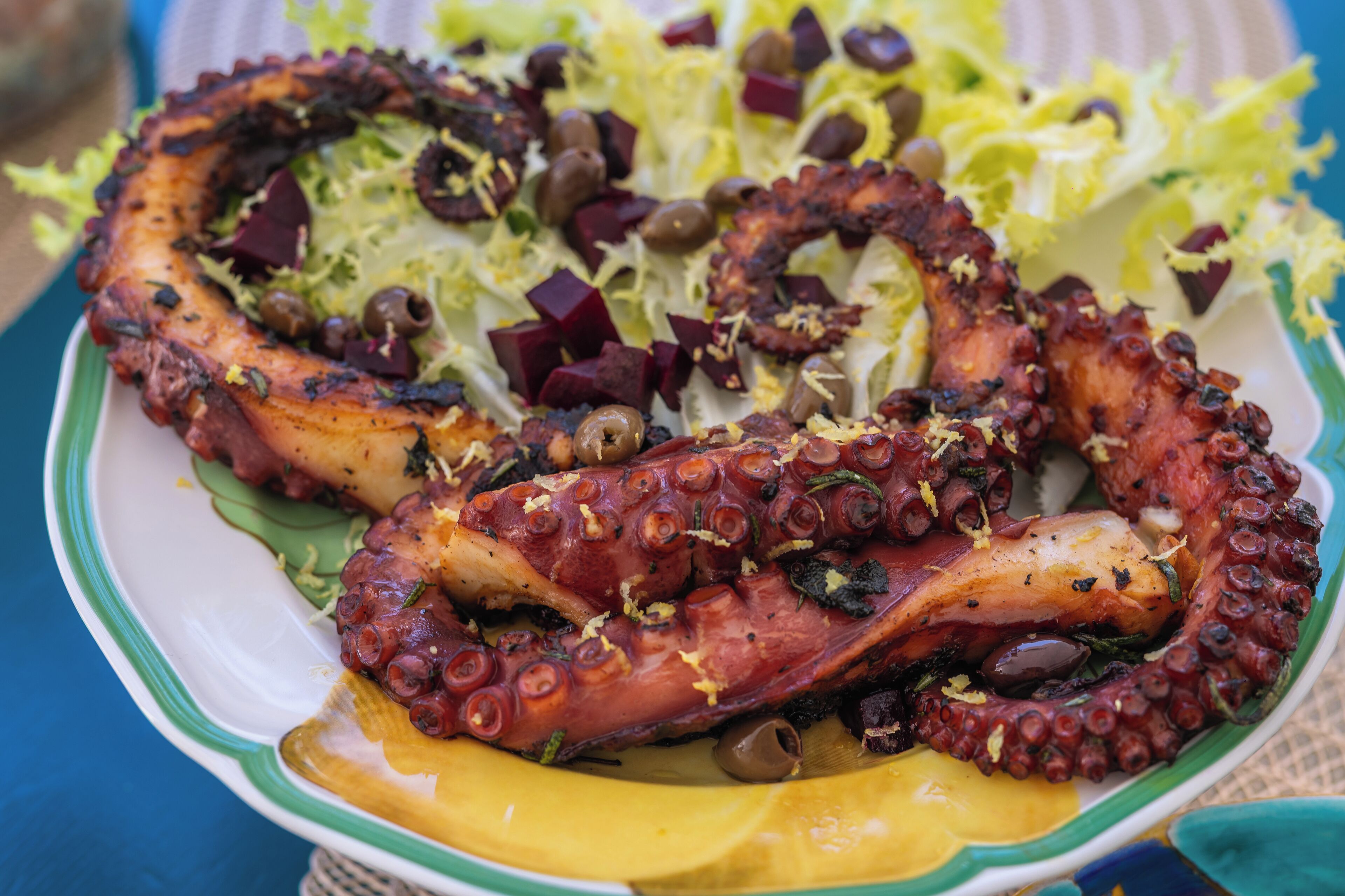 Une assiette de poulpe grillé, arrosé d’huile d’olive, de jus de citron et agrémenté d’herbes, accompagnée d’une salade.