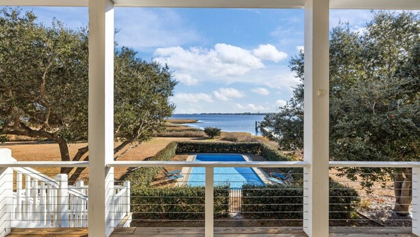 A view from a covered porch with a pool, overlooking a beach and ocean. - Waterfront Home w/ Pool, Private Dock & Fireplace in Newport NC (Newport)