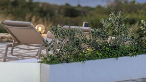A terrace with lounge chairs and a view of the sea. - Your Private Paradise with 2 Pools & Sea Views (Rethymno)