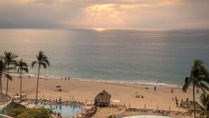 A beach resort with a pool area, palm trees, and a view of the ocean. - Ocean View in a Beach Front Resort and Spa.  (Incl. All-Inclusive for 2 Adults) (Puerto Vallarta)