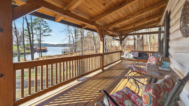 A wooden deck with a view of a lake, furnished with chairs and a table. - Lakefront Escape w/Private Water Access, Dock, Kayaks, & Fire Pit. Pet Friendly! (Sparta)