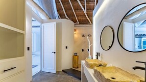 A modern bathroom with a large mirror, two sinks, and a wooden stool. - Hotel Qamar Lux (Tulum)