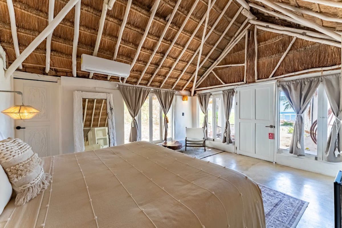 Une chambre spacieuse avec un grand lit, une chaise et une armoire.