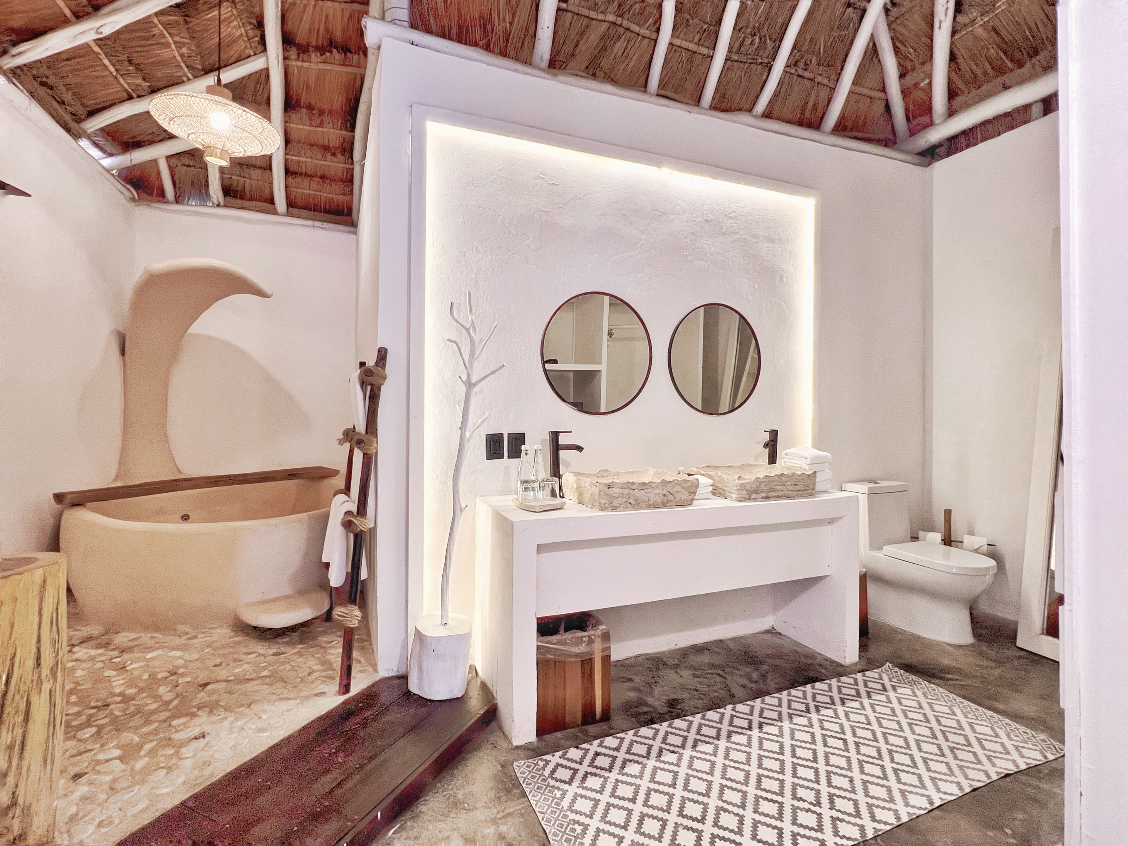 Un baño con bañera, un lavabo doble y un inodoro.