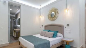 A bedroom with a bed, bedside table, and a mirror on the wall. - Peaceful 4-bedroom apartment in charming Madrid perfect for families (Madrid)