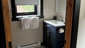 Een badkamer met een raam, een wastafel en een toilet.