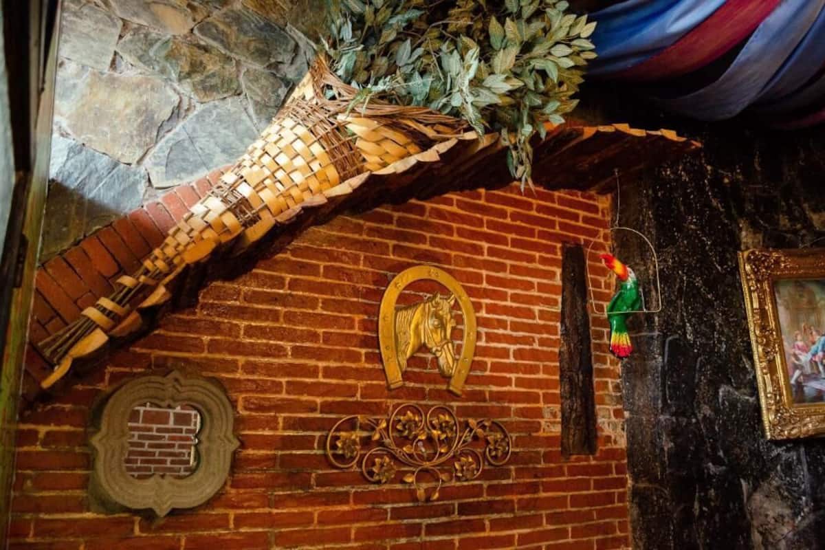 A brick wall with a decorative metal horse head and a circular emblem.