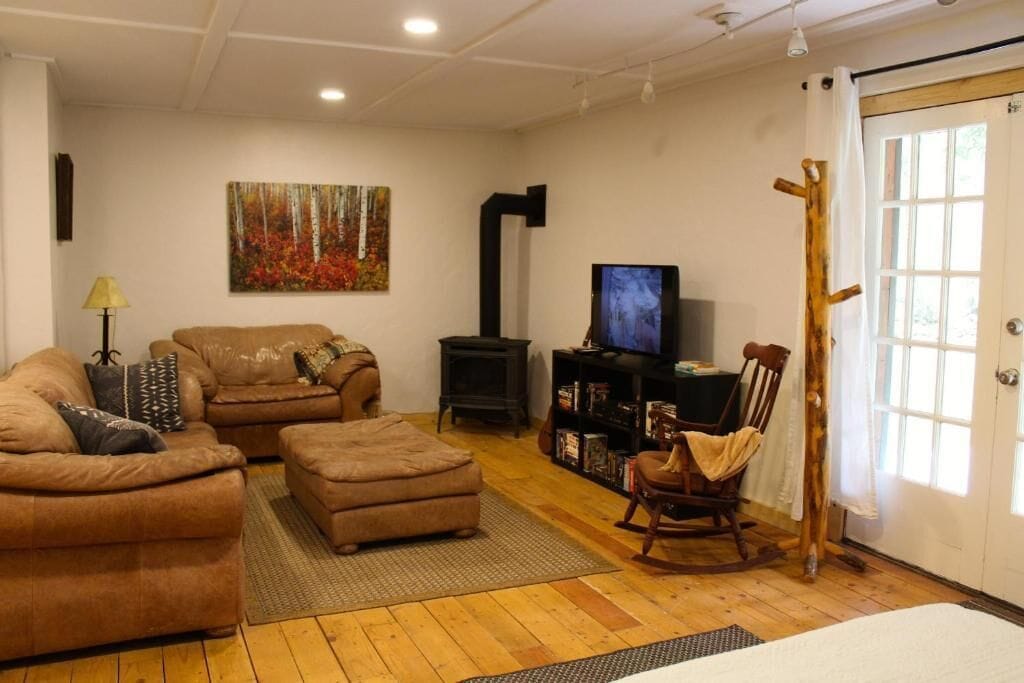 A cozy living room with a sofa set, a television, a bookshelf, and a painting on the wall.