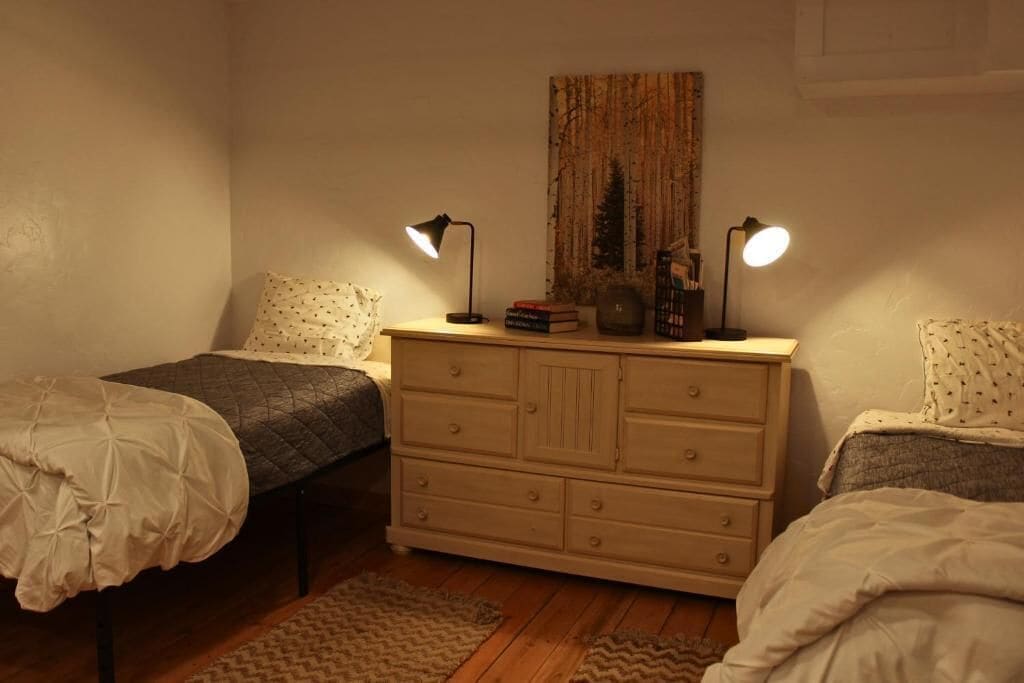 Ein Schlafzimmer mit zwei Betten, einem Schminktisch und zwei Nachttischlampen.