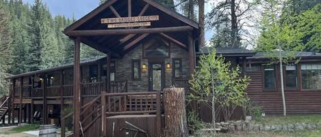 A rustic lodge with a prominent sign, wooden exterior, and a deck area.