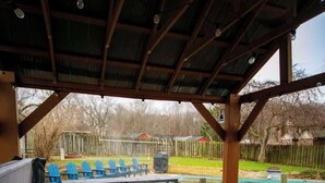 A hot tub under a wooden pergola with a view of a backyard and a swimming pool. - Vino Villa | Cozy Escape near Wineries & Lake (Coloma)