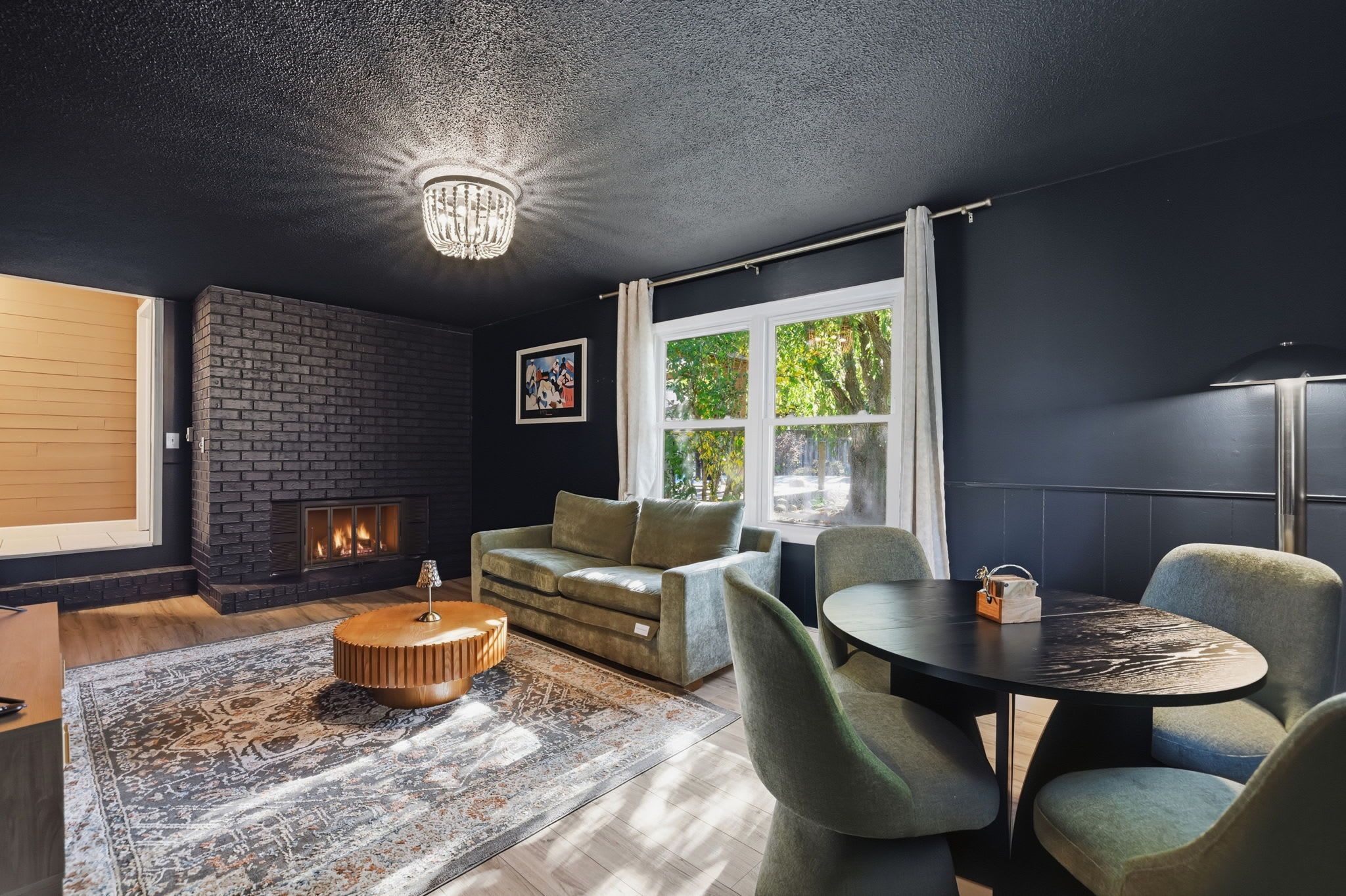 A modern living room with a fireplace, a round coffee table, and a sofa.