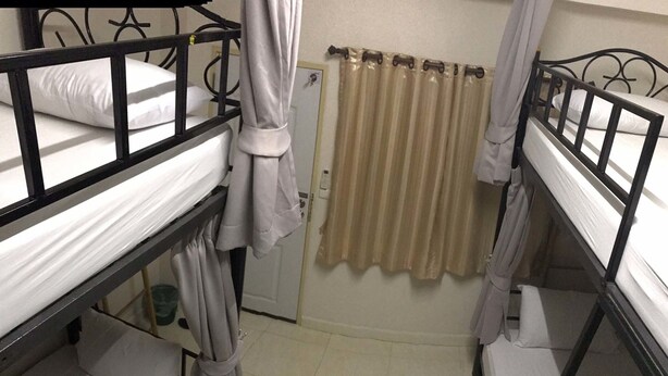 A dormitory room with bunk beds, a curtain, and a radiator. - Bunkboutique FC (Chiang Mai)