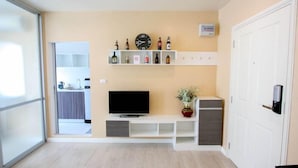 A modern living room with a flat-screen TV, a clock, and a shelf with bottles. - D Condo Sign Chiang Mai R628 (Chiang Mai)