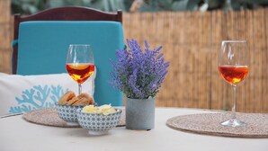 A table set with two glasses of red wine, a bowl of pastries, and a potted lavender plant. - Villasimius - Villa Sofia (Cala Caterina)