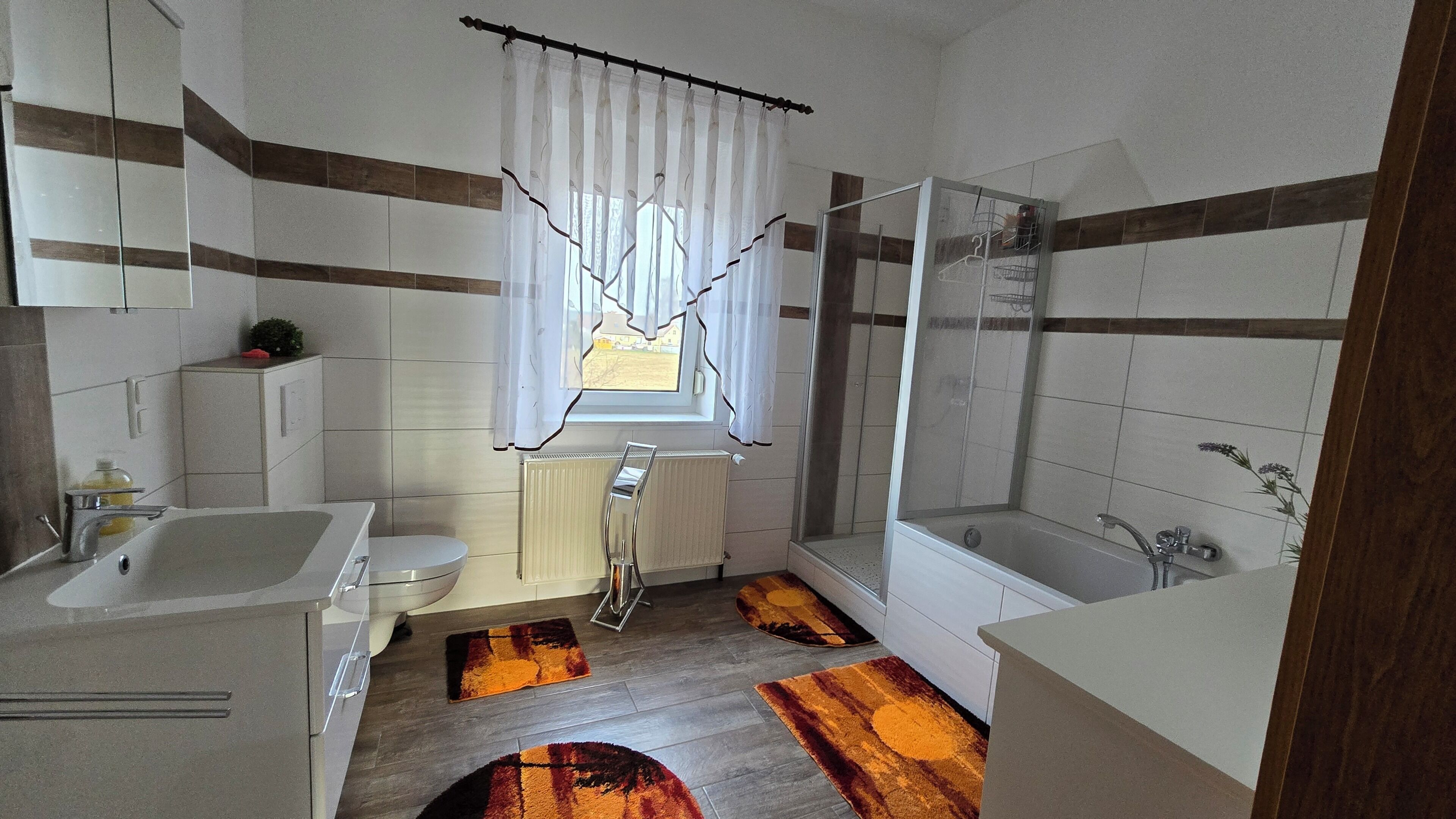 A modern bathroom with a shower, toilet, and sink.