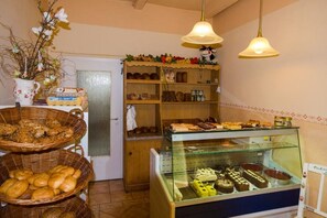 A bakery display with various baked goods and a glass case of desserts. - Pachow's Eichenhof Vacation Rental & Farm Store (Lohsa)