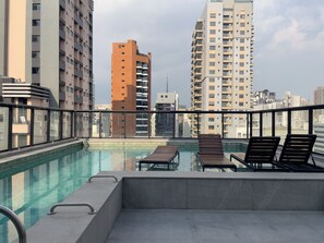 Een buitenzwembad, parasols voor strand/zwembad