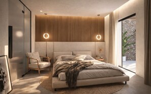 A modern bedroom with a large bed, a side table, a chair, and a view of a stone wall through a large window.