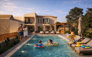 A pool area with lounge chairs, a pool, and a building with a stone facade.
