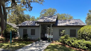 A two-story building with a covered porch, a private pool, and a well-maintained lawn. - Feels like Home on Hilton Head Island (Hilton Head Island)
