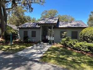 A two-story building with a covered porch, a private pool, and a well-maintained lawn. - Feels like Home on Hilton Head Island (Hilton Head Island)