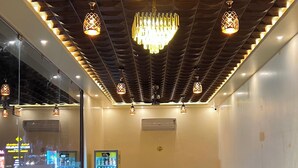 Un lobby moderno con candelabro, área de descanso y máquinas expendedoras.