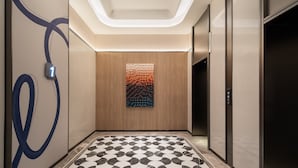 A modern elevator interior with a patterned floor, a wall-mounted artwork, and a digital display showing the number 1. - Holiday Inn Express Kunming Dianchi Rixin Road By Ihg (Kunming)