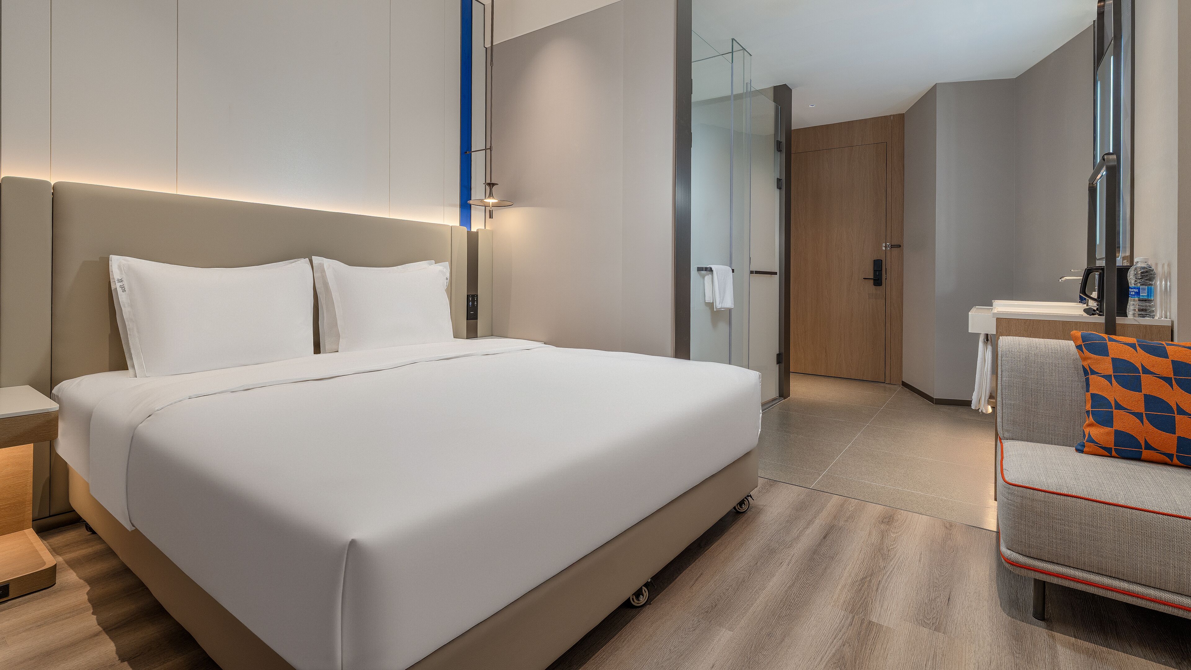 Une chambre d’hôtel moderne, dotée d’un grand lit, d’un bureau et d’une chaise.