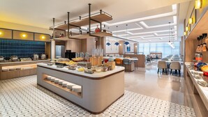 A modern hotel lobby with a central bar area, seating arrangements, and a large window providing natural light. - Holiday Inn Express Kunming Dianchi Rixin Road By Ihg (Kunming)