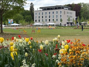 A building with a modern architectural style, a grassy field with colorful flowers, and outdoor seating areas. - Holiday Inn Express & Suites Ellwangen by IHG (Ellwangen)