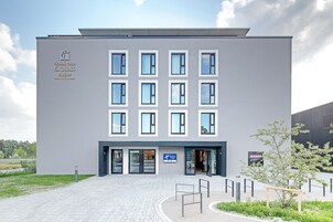 Un edificio moderno con fachada plana, múltiples ventanales y un letrero que indica que es un Holiday Inn Express & Suites.