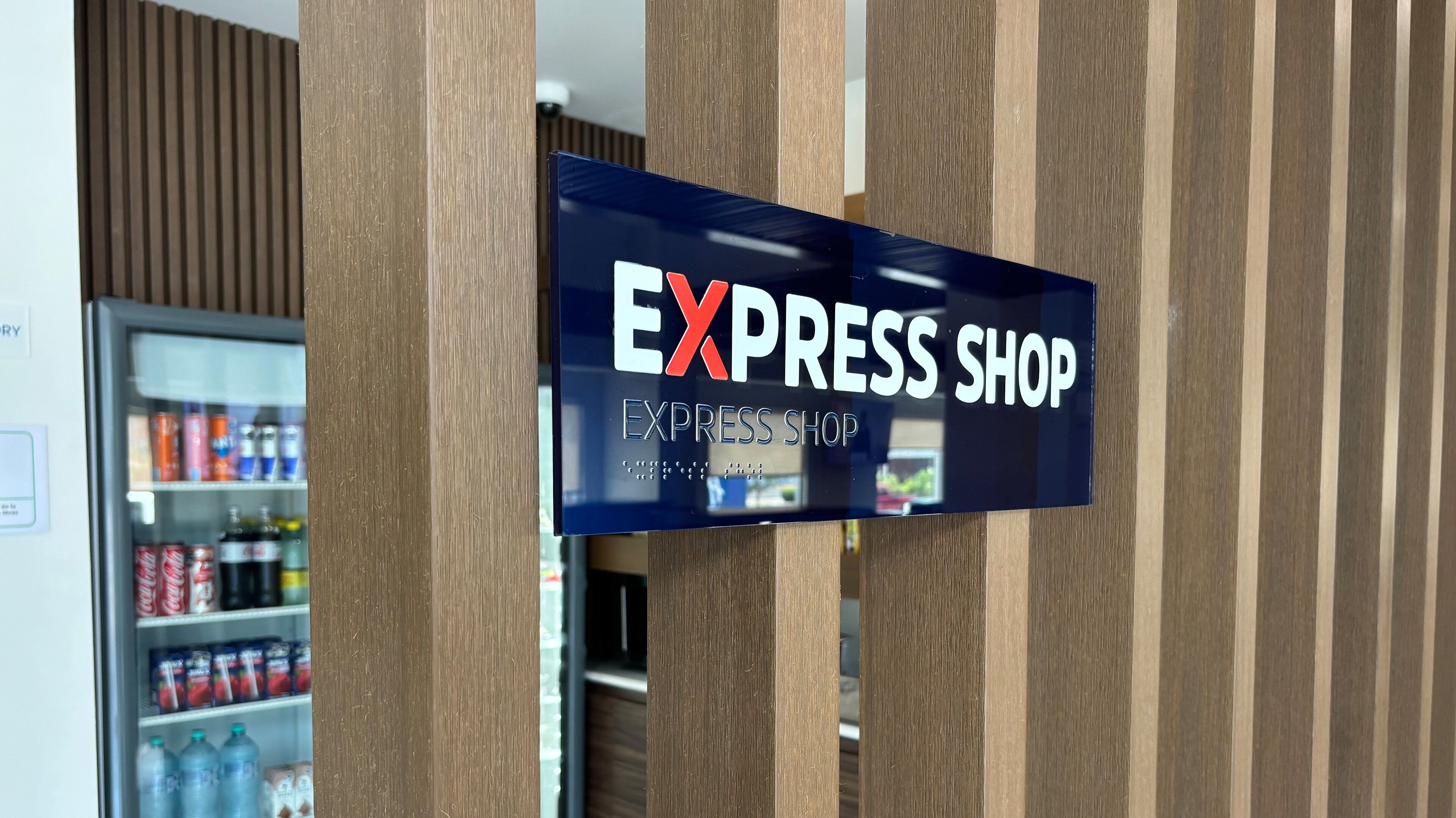 A sign for an Express Shop with a clear view of a vending machine in the background.