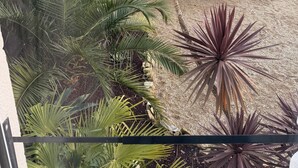 Un edificio de piedra con techo inclinado, rodeado de diversas plantas.