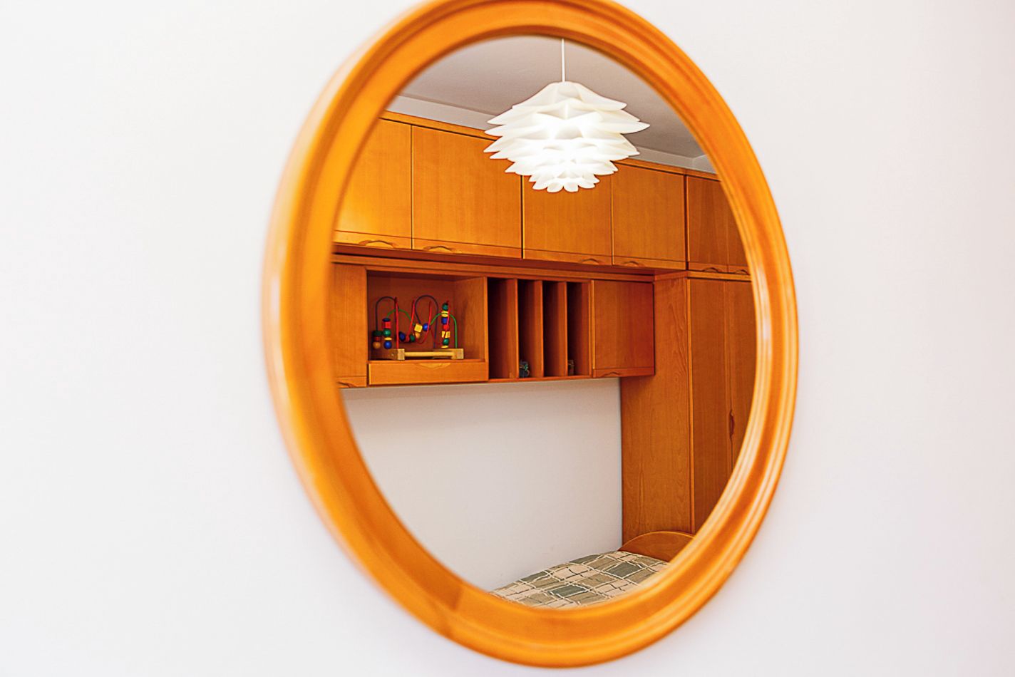 Ein Zimmer mit Holzausstattung, einer weißen Deckenleuchte und einem gemusterten Boden.