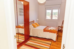 Une chambre à coucher avec un lit, une chaise, une fenêtre et une porte.