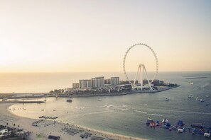 A coastal cityscape with a prominent Ferris wheel, a marina with boats, and a beachfront area. - Rimal - Two Bed with Sea an Ain Dubai View in JBR (Jumeirah Beach Residence)