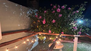 A garden with a wooden pergola, string lights, and pink flowers. - Oceanfront Beach House at Parada 23 La Mansa - Direct Beach Access (Punta del Este)