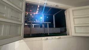 An open window with a view of a patio area at night, including a table and chairs. - Oceanfront Beach House at Parada 23 La Mansa - Direct Beach Access (Punta del Este)