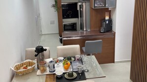 A modern kitchen with a dining area. - Apartment - Jewel Ingleses Santinho 5 minutes from the beach (Florianópolis)