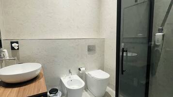 Deluxe tweepersoonskamer | Badkamer | Een douche, een haardroger, handdoeken, zeep