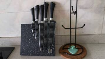 A kitchen counter with a knife block and a metal hook.
